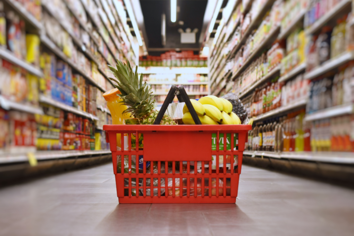 Grocery basket sitting in an aisle.
