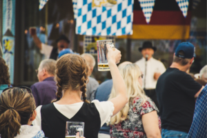 Woman holding a mug up in a crowd.