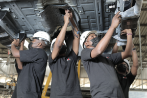 Auto workers assembling a car.