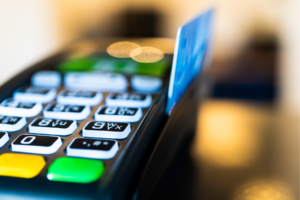 Debit card being swiped on a machine.