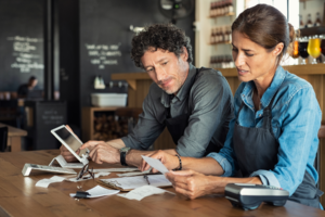 Two people reviewing receipts and other financial statements.