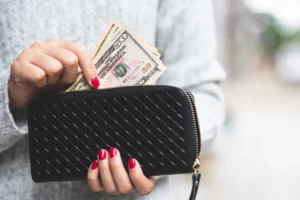 Woman grabbing cash from her purse.