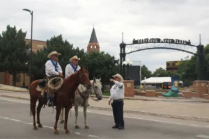 Cheyenne Frontier Days Parade riders in front of Depot Plaza sign.