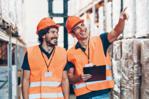 Warehouse workers in orange vests.