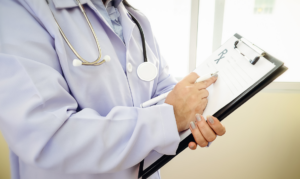 Doctor writing on a clipboard.