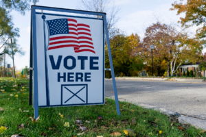 "Vote Here" sign on a lawn.