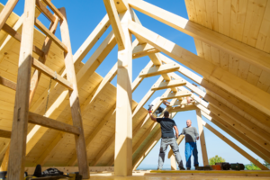 Two men building a roof.