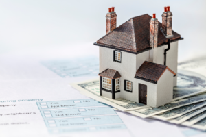 Small model house on tax forms.
