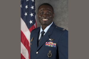 Colonel Galbert in uniform in front of the American flag.
