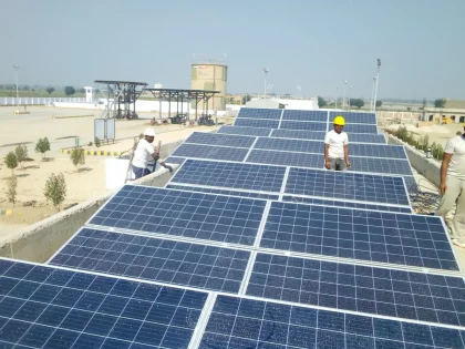 Solar panels installed on an industrial manufacturing facility rooftop in daylight