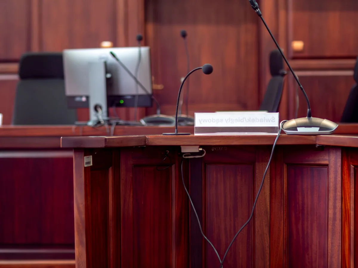 Courtroom interior with judge's bench, gavel, and legal documents in soft lighting