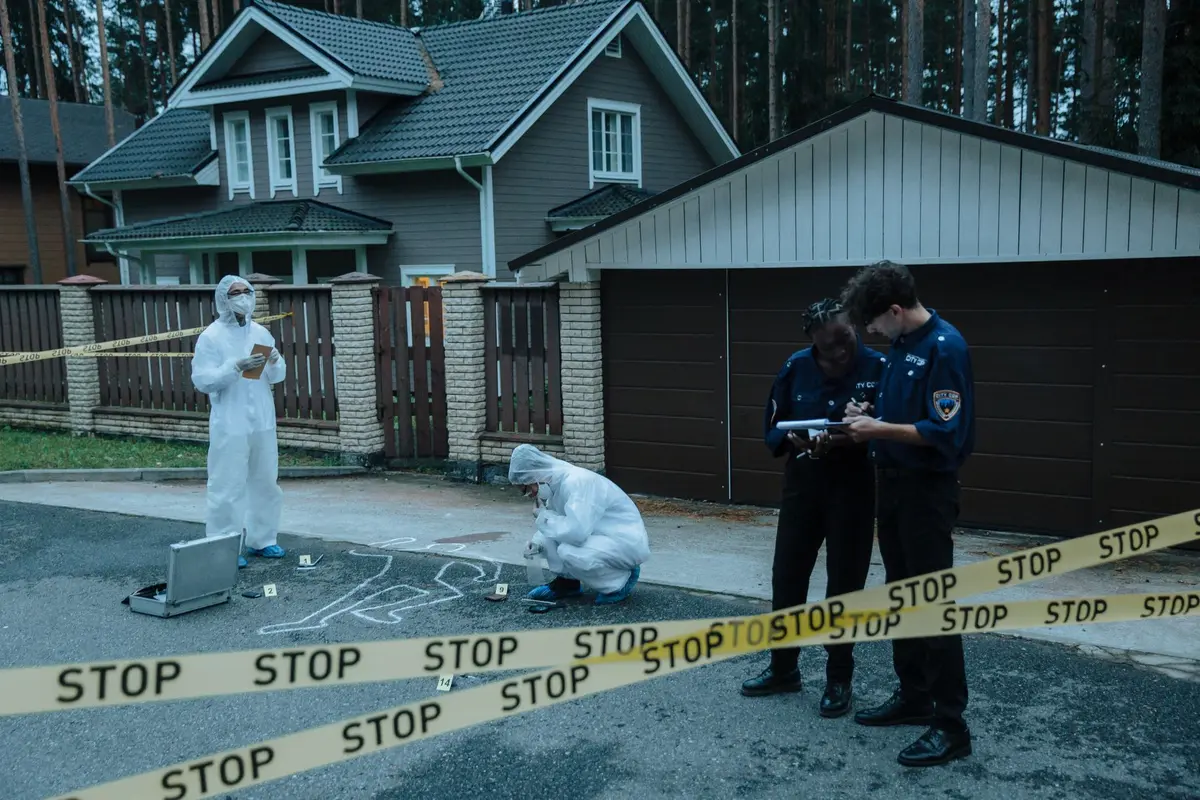 Detectives processing evidence at a residential crime scene indoors
