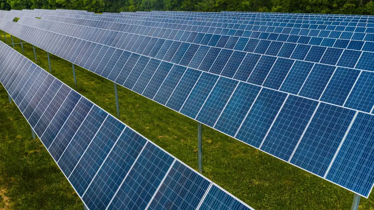 Utility-scale solar array installation with multiple panels mounted on ground structures in open terrain