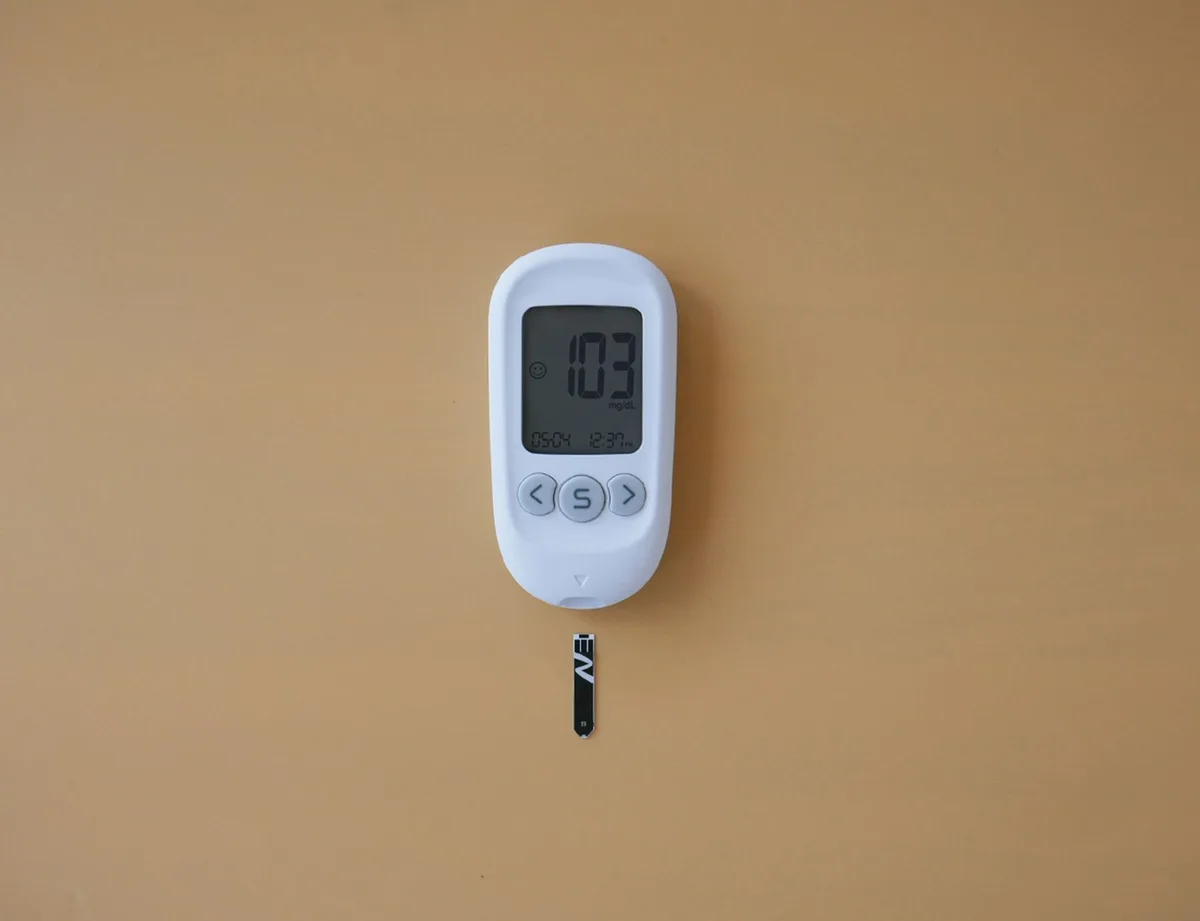 Blood glucose meter and test strips on a white surface