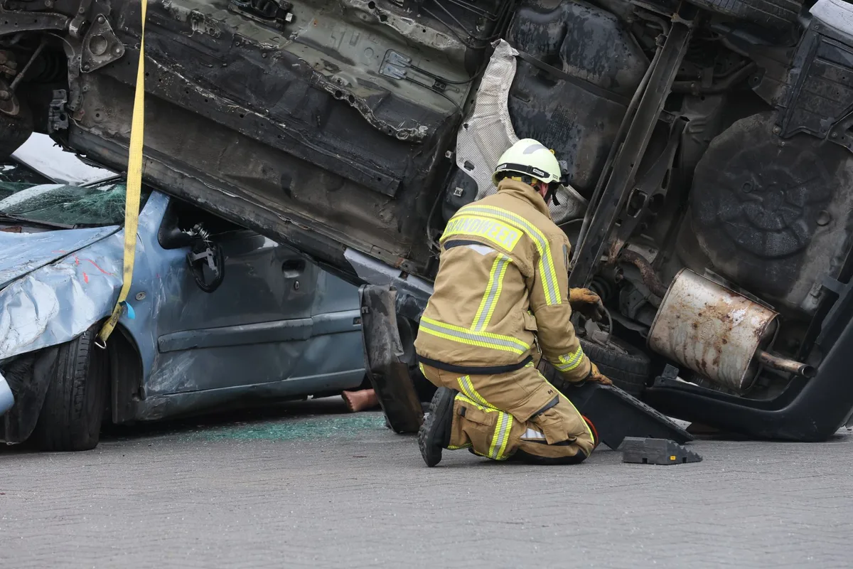 Emergency responders work at the scene of a serious vehicle rollover crash on a rural road