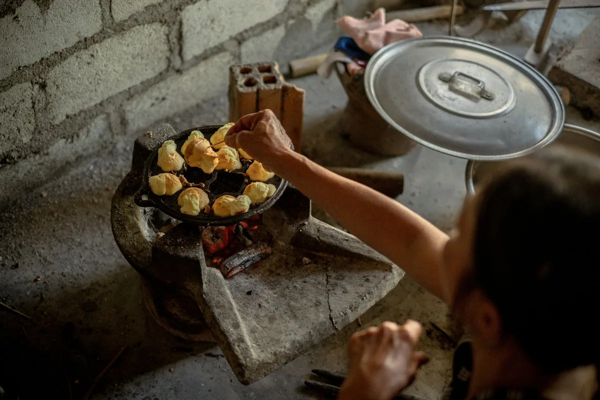 Familia cocinando con estufa de carbón e iluminación de linterna durante apagón