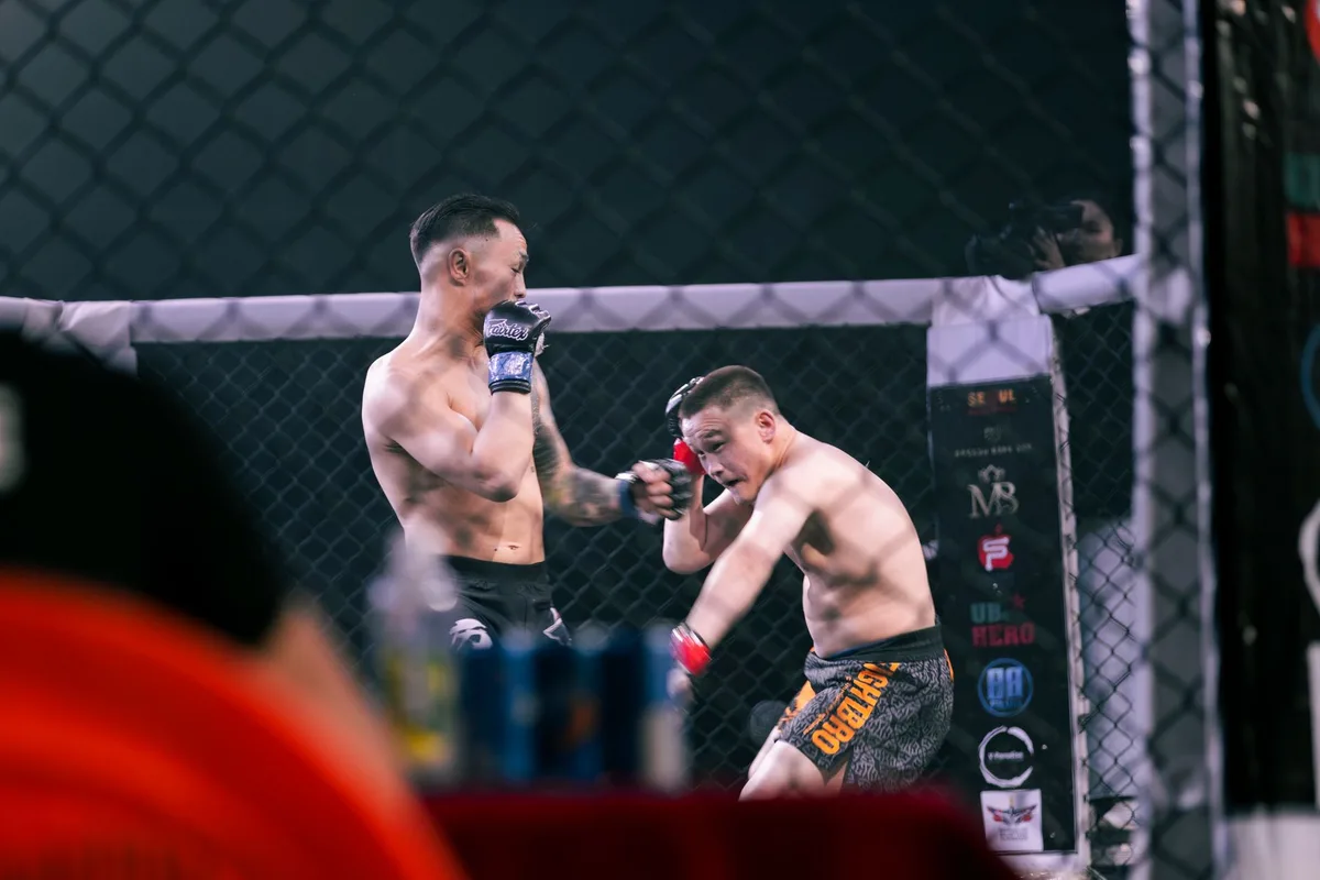 Two MMA fighters engaged in striking exchange inside the octagon during a professional bout