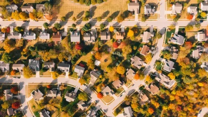 Two people in a tense confrontation on a residential street between suburban homes