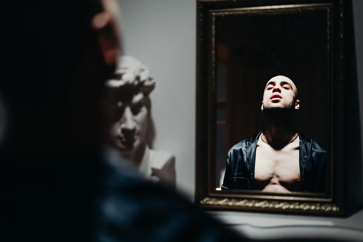 Person looking at their reflection, contemplating personal identity and change