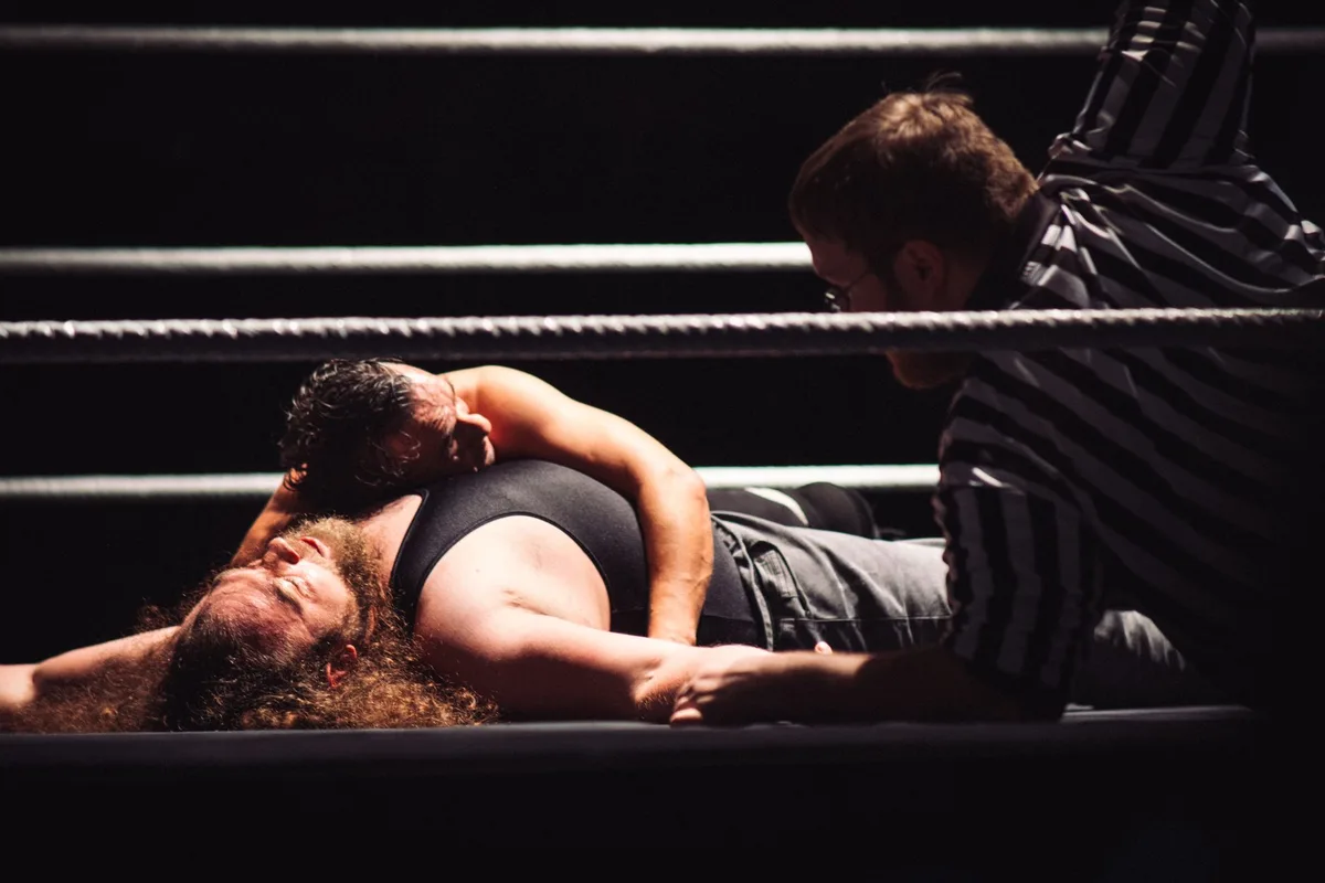 Zwei Wrestlerinnen halten gemeinsam eine Meisterschaftsgürtel
