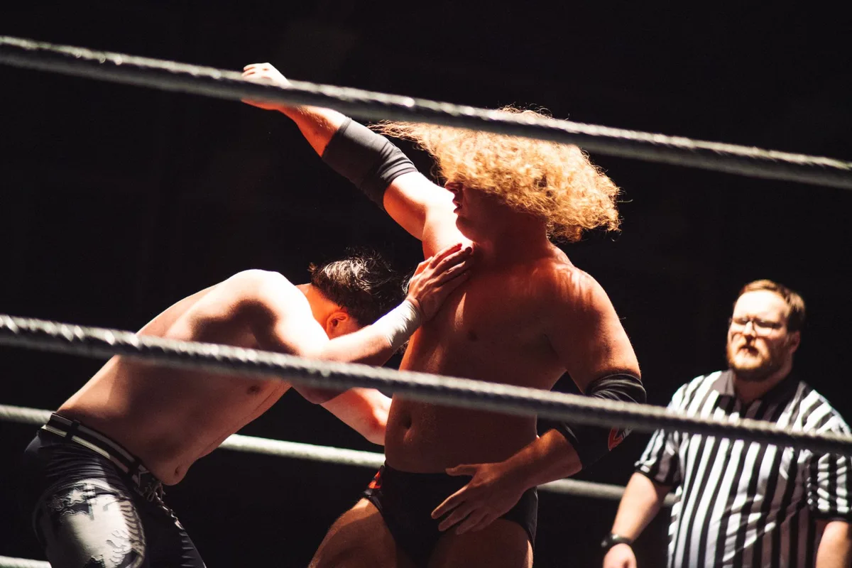 Wrestler im Ring während eines intensiven Kampfes vor jubelndem Publikum