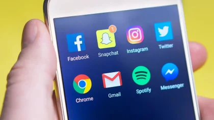 Person holding a smartphone displaying social media app with notifications on screen