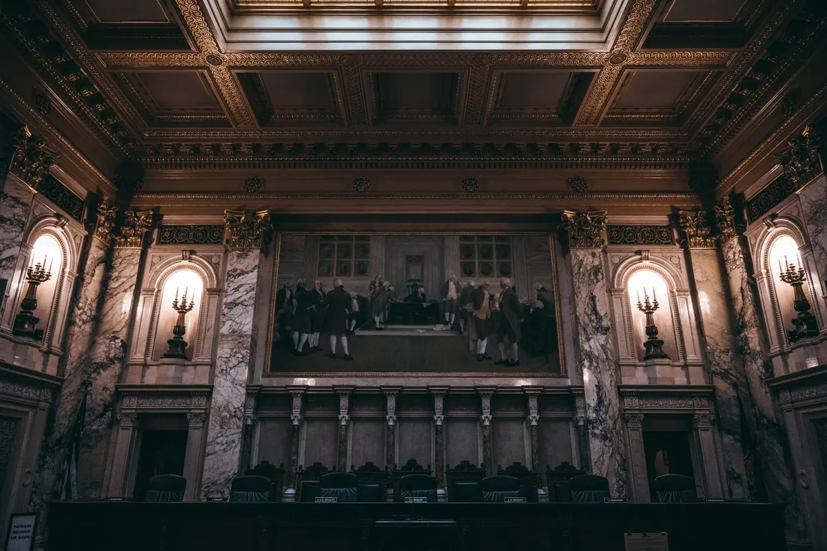 Législative redistricting maps with colored district boundaries displayed in a Capitol chamber