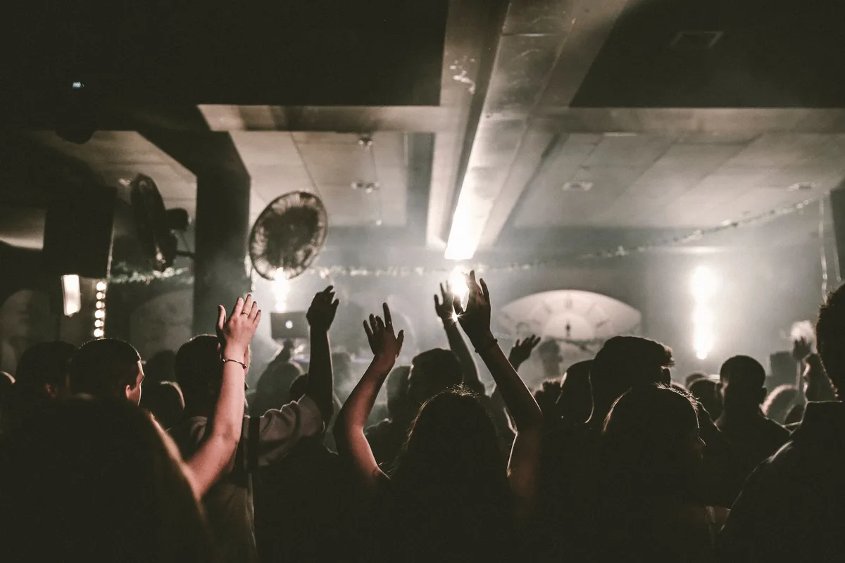 Crowded nightclub interior with patrons and dim lighting, illustrating high-tension alcohol-fueled environments