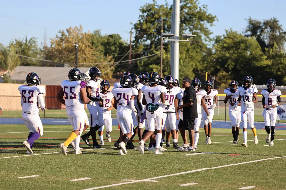 College football players huddle together on the field during a game