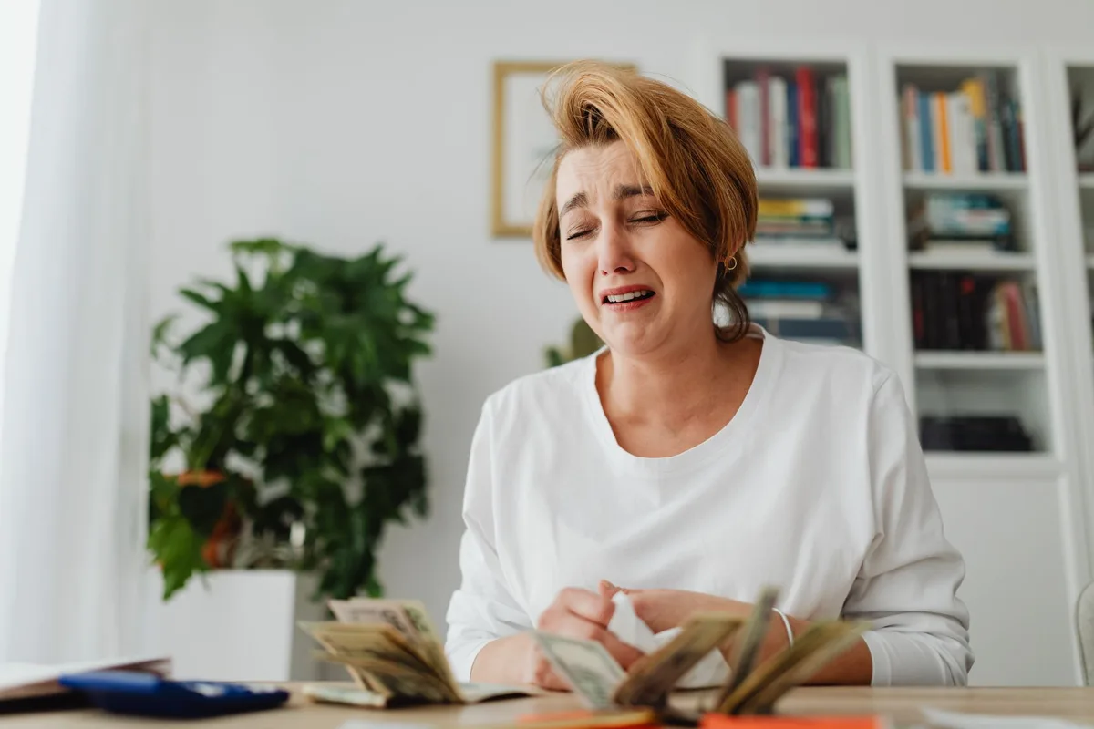 Person reviewing household bills and expenses during economic hardship