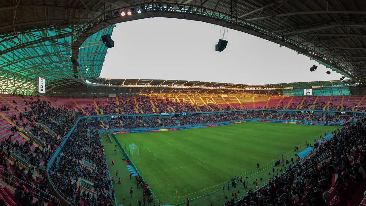 International stadium crowd watching a football match, illustrating global expansion debate