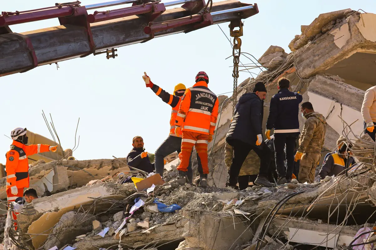 Rescue workers searching through rubble and debris from collapsed residential buildings