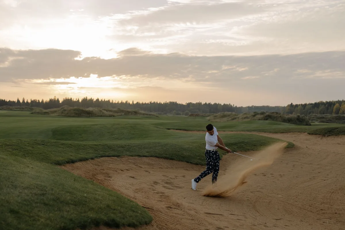 Golfer executing a recovery shot from a bunker during tournament play