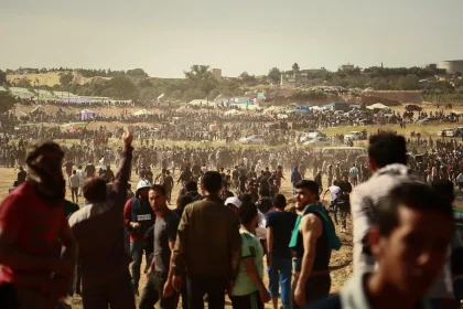 Crowd of supporters at a political rally with raised hands and flags