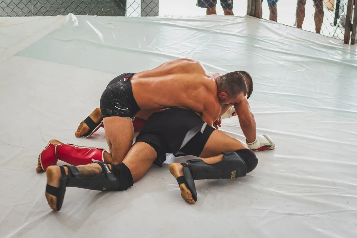 Two MMA fighters in combat stance inside the octagon during an intense match