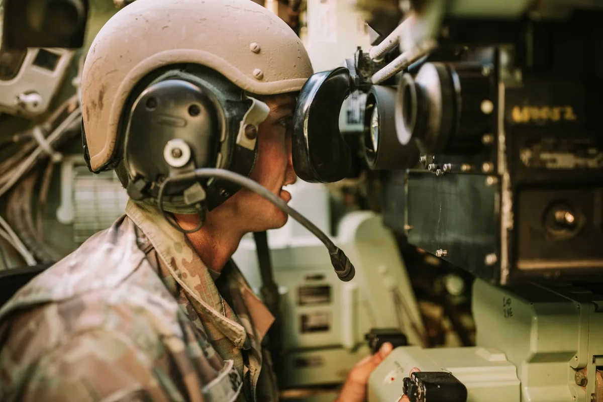 Technicians monitoring autonomous systems and electronic warfare equipment during field trials