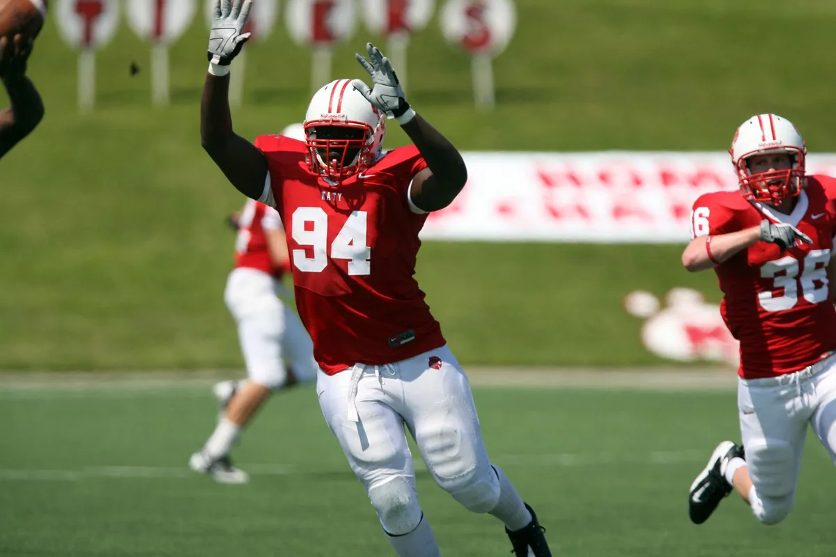 Defensive players rushing the quarterback during a college football game