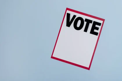 Person marking a paper ballot at a voting station