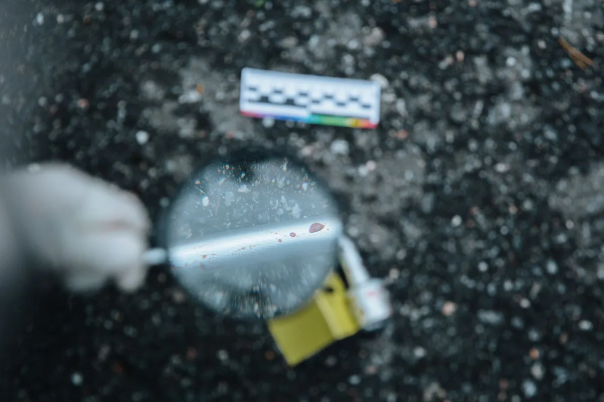 Smartphone and forensic tools on a desk during a criminal investigation