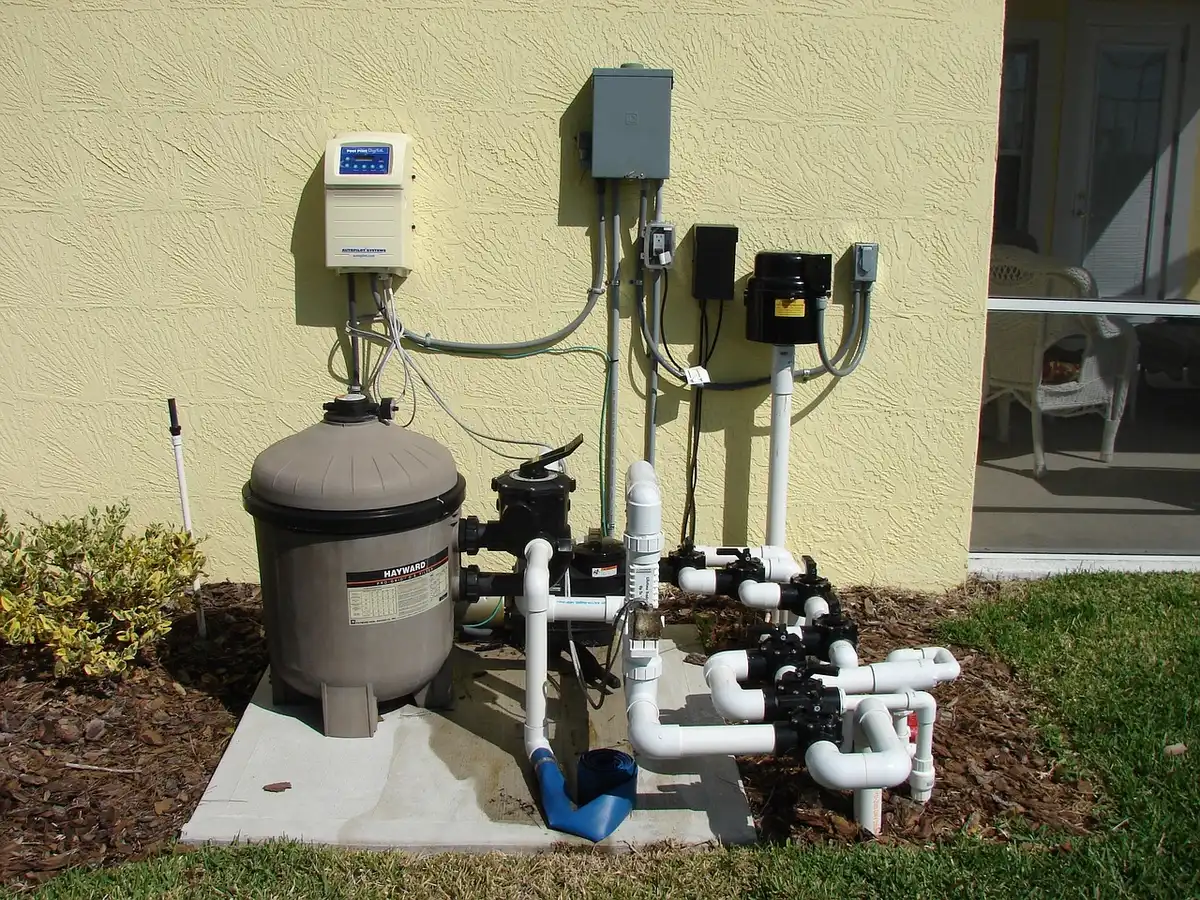 Workers' hands and coiled water pipe beside a curb during utility repair