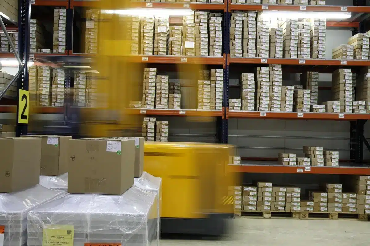 Stacks of printed ballots and staff preparing mailing trays in an election office