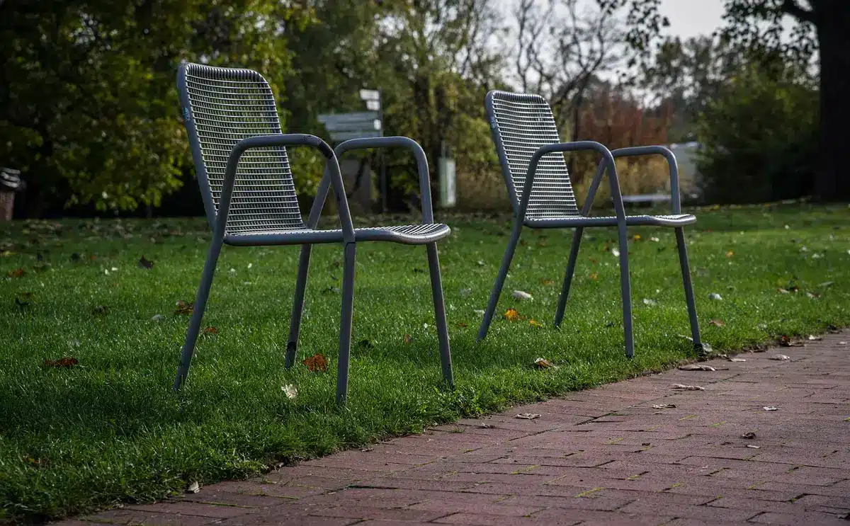 Two chairs spaced apart and a folded note, suggesting requested distance