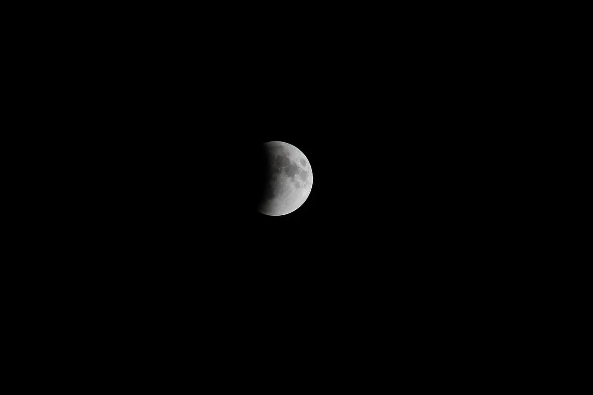 A journal beside a dim crescent-lit shadow suggesting introspection