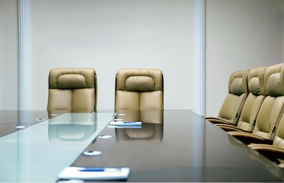 A panel of officials and clinicians at a policy hearing in a conference room