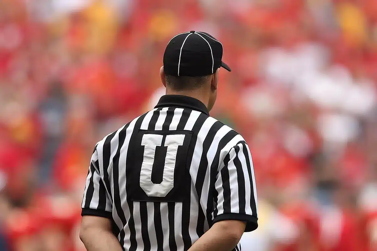 Officials checking the game clock after a controversial end-of-game decision in a football match.