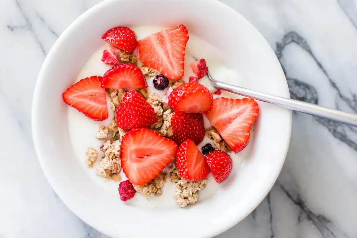 A bowl of Greek yogurt topped with granola, nuts, seeds, and berries for a high-protein breakfast