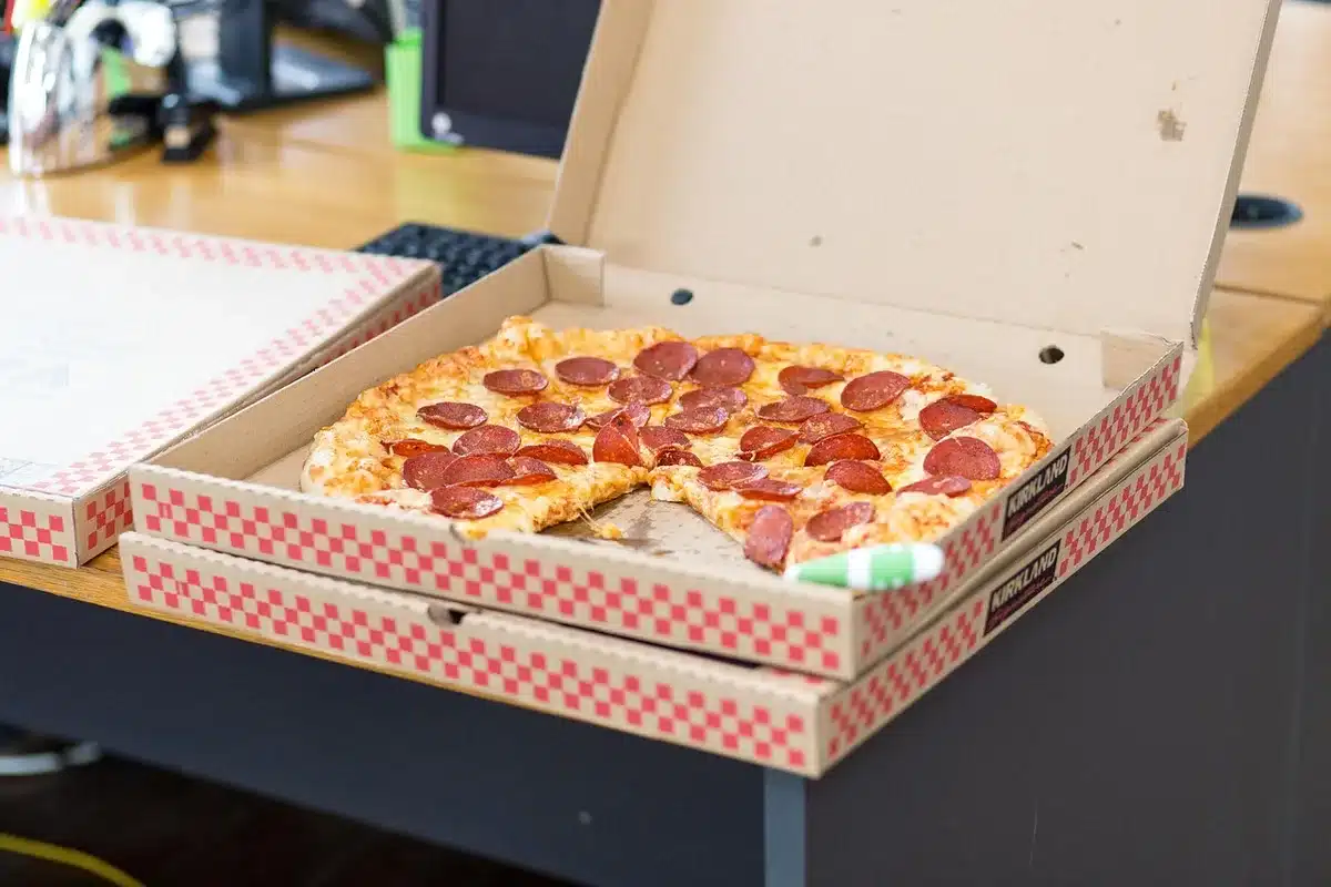 Slice of pizza crisping in a skillet to show stovetop reheating method