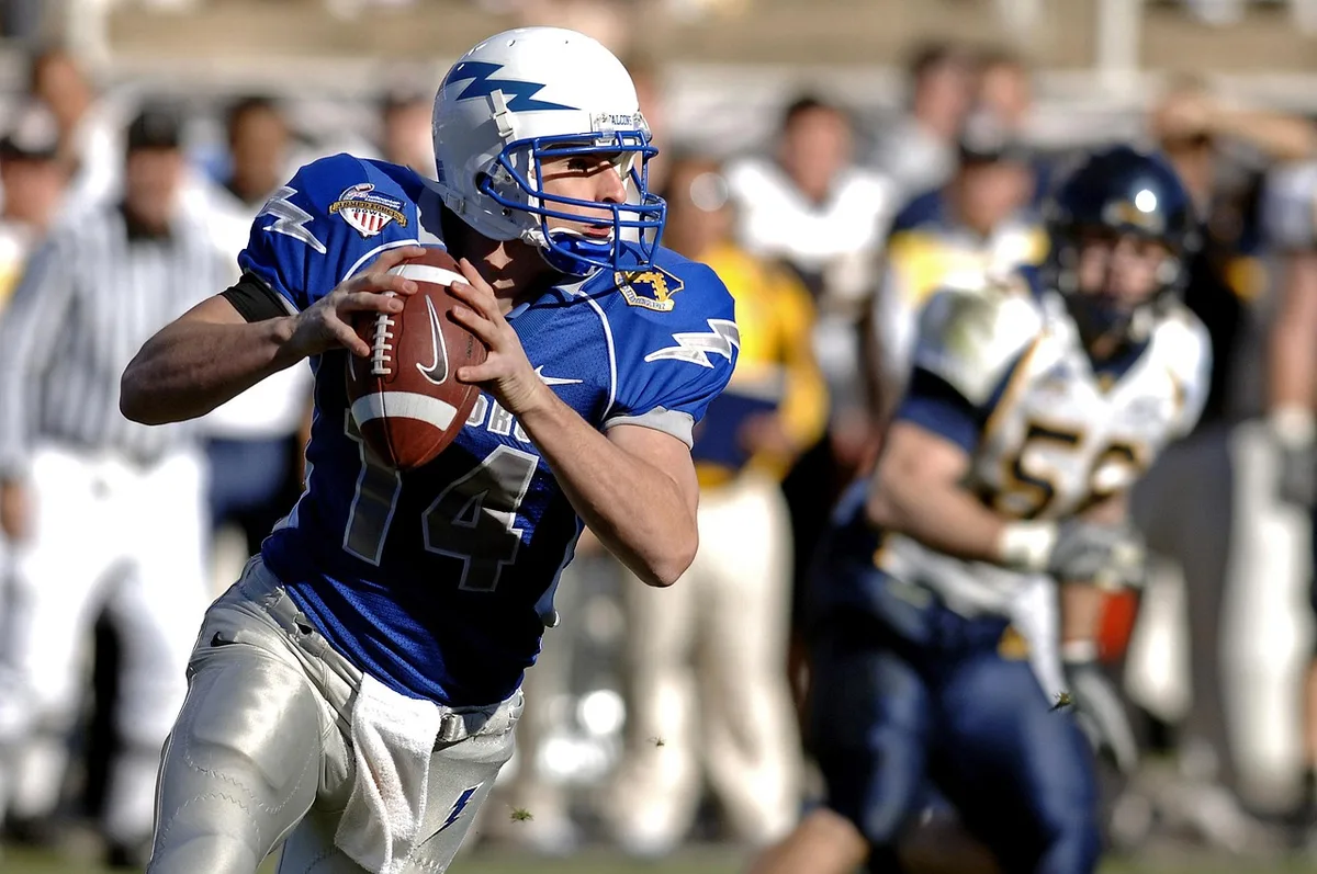 Quarterback throwing to wide receiver downfield during a football game
