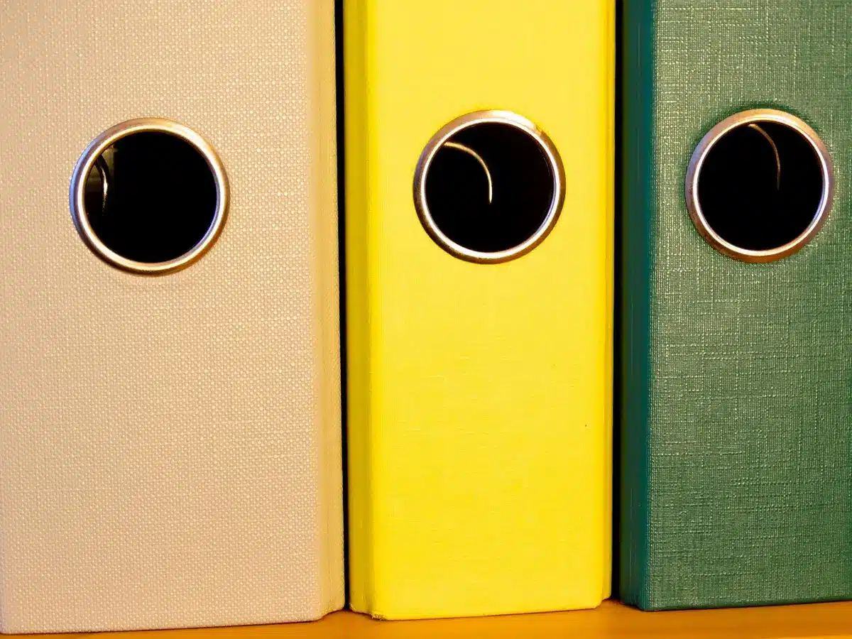 Stack of unbranded binders and procedural manuals on a table