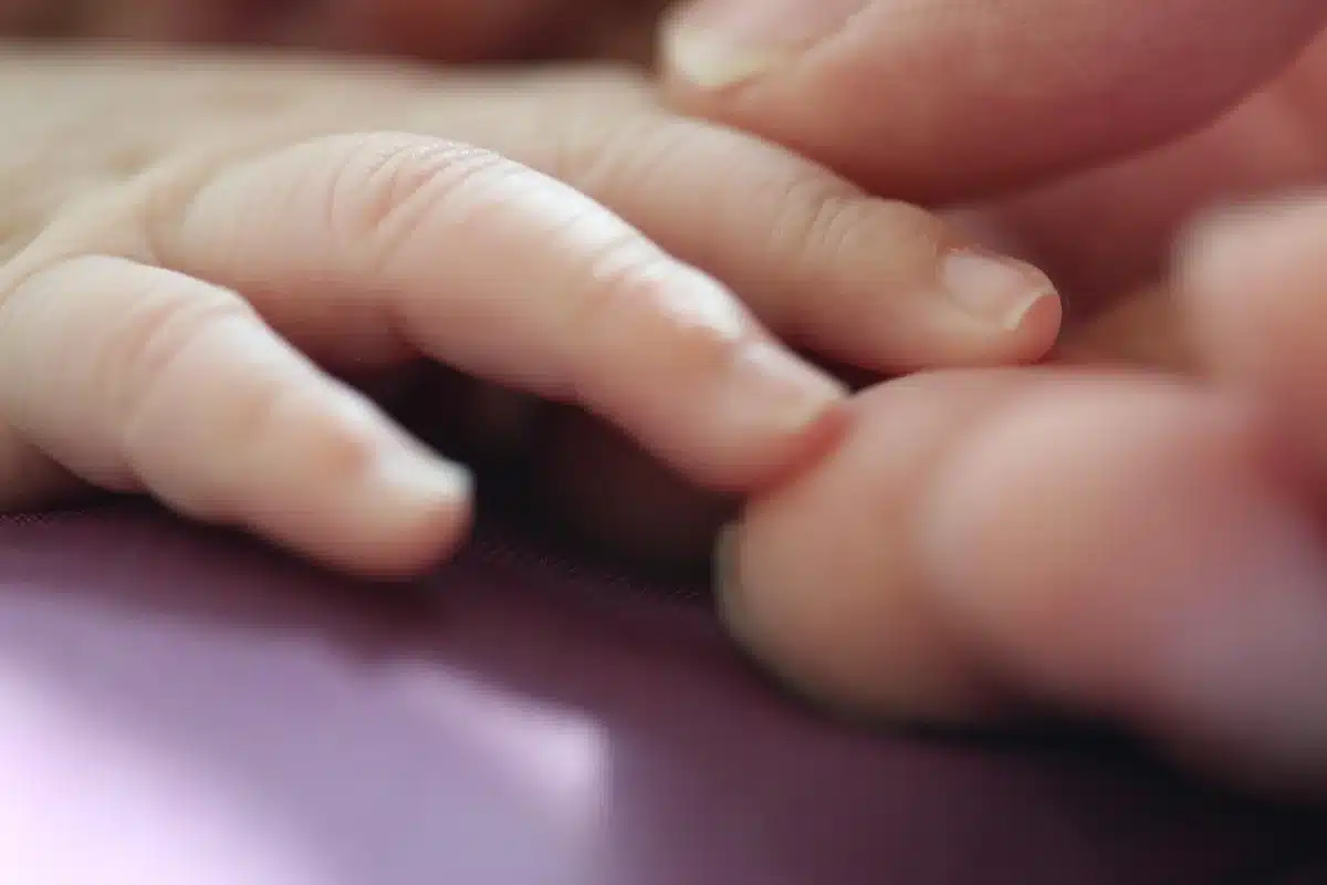 Anonymous parents holding an infant's feet